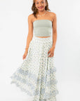Model twirling in Free People Ivory Combo One Brynn Printed Maxi Skirt, highlighting its lightweight fabric and boho chic floral design.