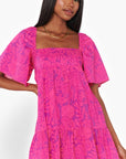 Pink Shells Erin Mini Dress with a relaxed fit, ruffled hem, and breezy short sleeves, ideal for beach vacations and warm-weather outings.