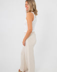 Side view of Free People Clean Ivory So Soft Seamless Modal Tank showing stretch fit and comfort, paired with wide-leg neutral pants.