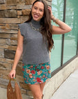 Rowan Grey Mockneck Sweater Tank styled with floral mini skirt and brown accessories for a cozy yet festive winter look.