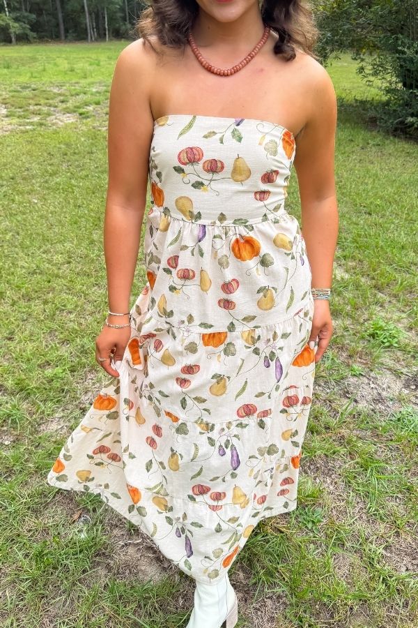 Heirloom Pumpkin Harvest Strapless Midi Dress with fall-themed print, worn outdoors, ideal for Thanksgiving and autumn events.