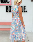 Woman wearing a colorful patterned dress in front of a store sign.