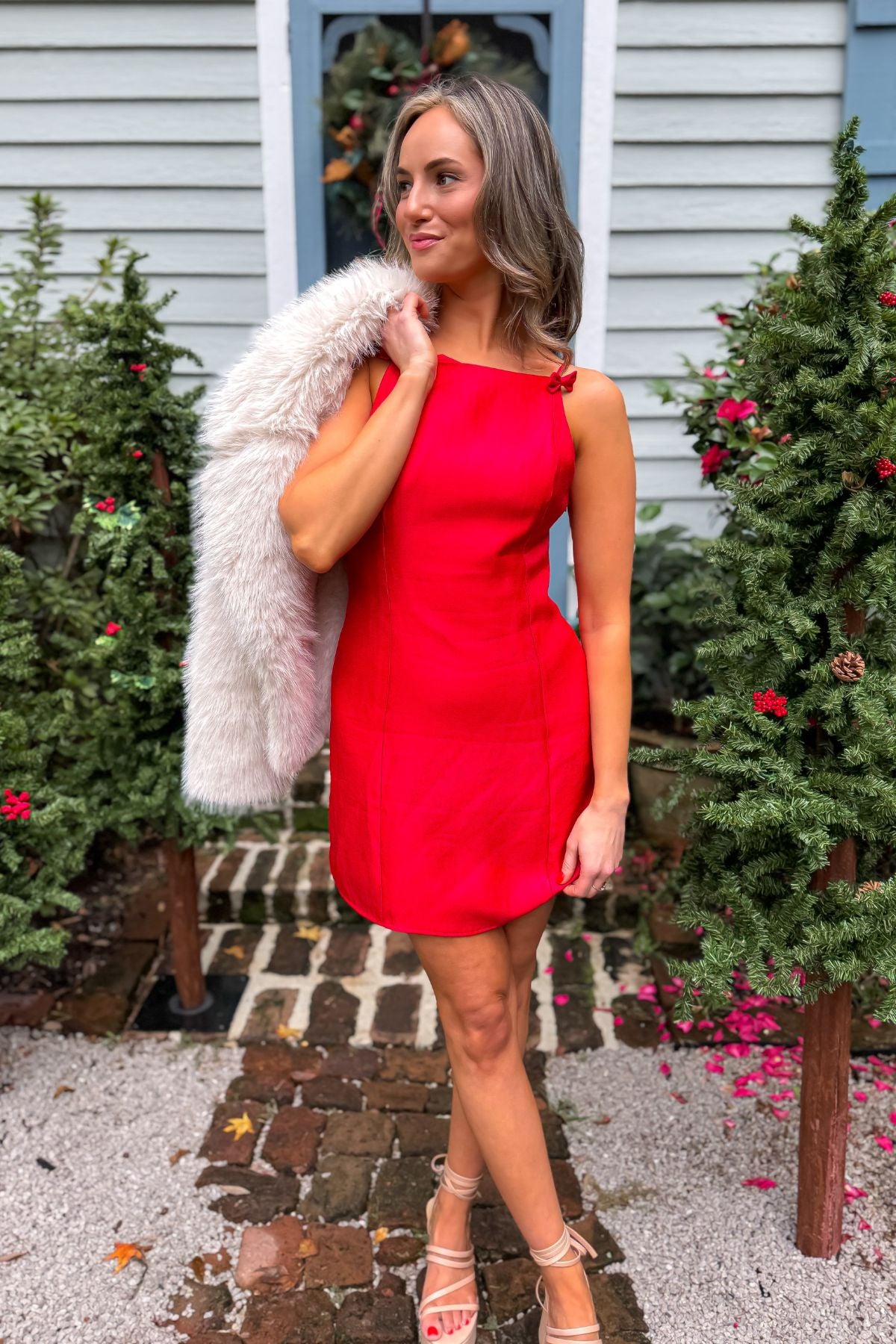 Noelle Red Bow Square Neck Mini Dress styled for the holidays with faux fur shawl, ideal festive outfit for Christmas parties and winter events.