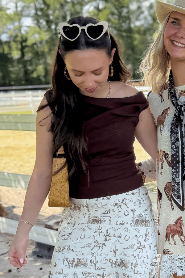 Friday Feeling Brown Asymmetrical Top styled with western print skirt, perfect for fall fashion and outdoor gatherings.