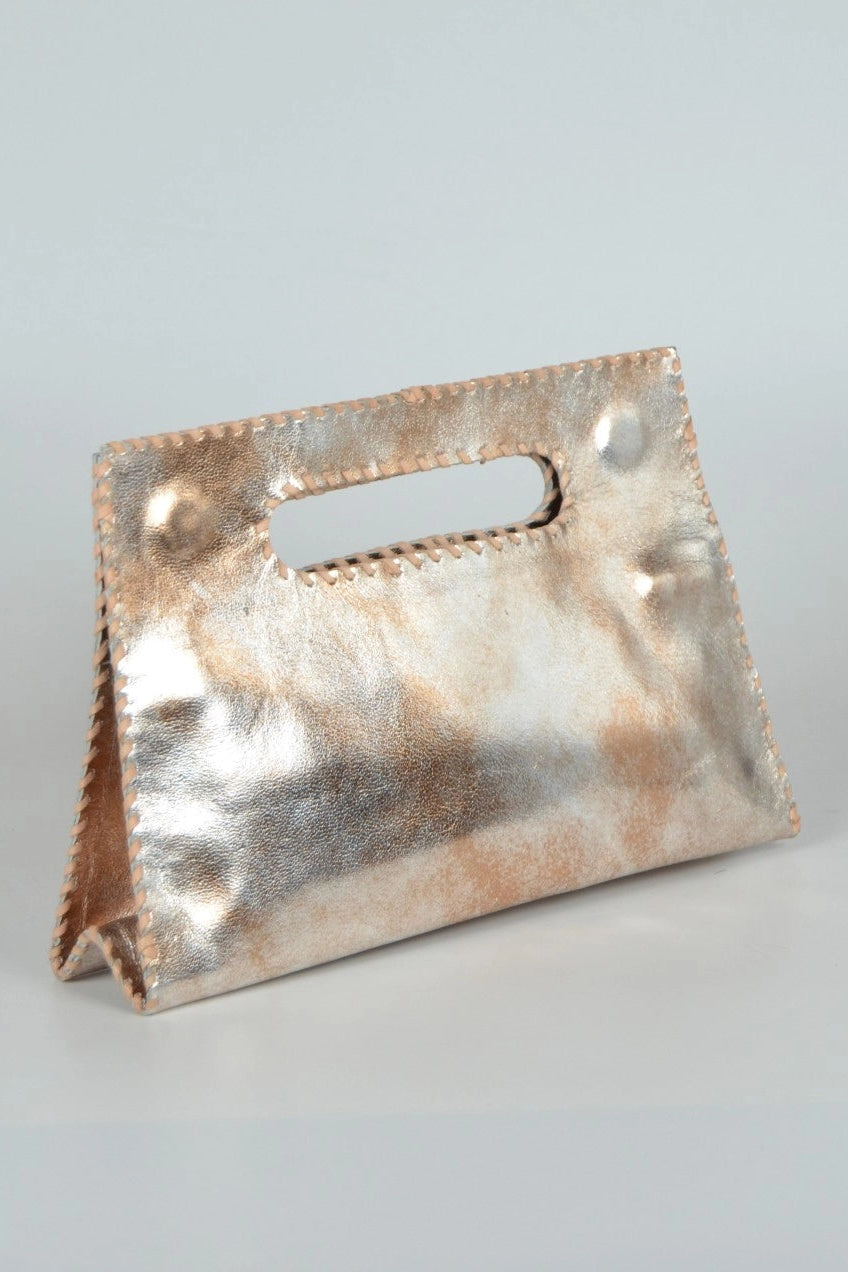 A metallic rose gold leather handbag with a top handle cutout, standing upright on a light gray background.