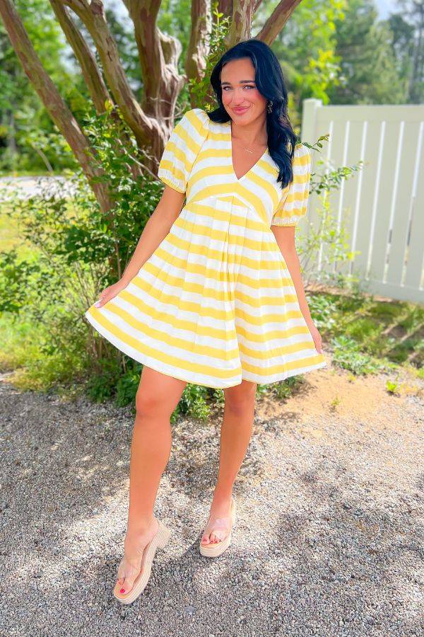 Sunshine style in our Sweetest Surprise Yellow V Neck Mini Dress with puff sleeves and flared babydoll fit, perfect for casual summer outings.