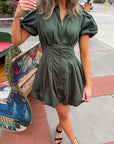 Arden Hunter Green Bubble Dress with puff sleeves, gold zipper, and pleated bubble hem styled for a festive outdoor look.