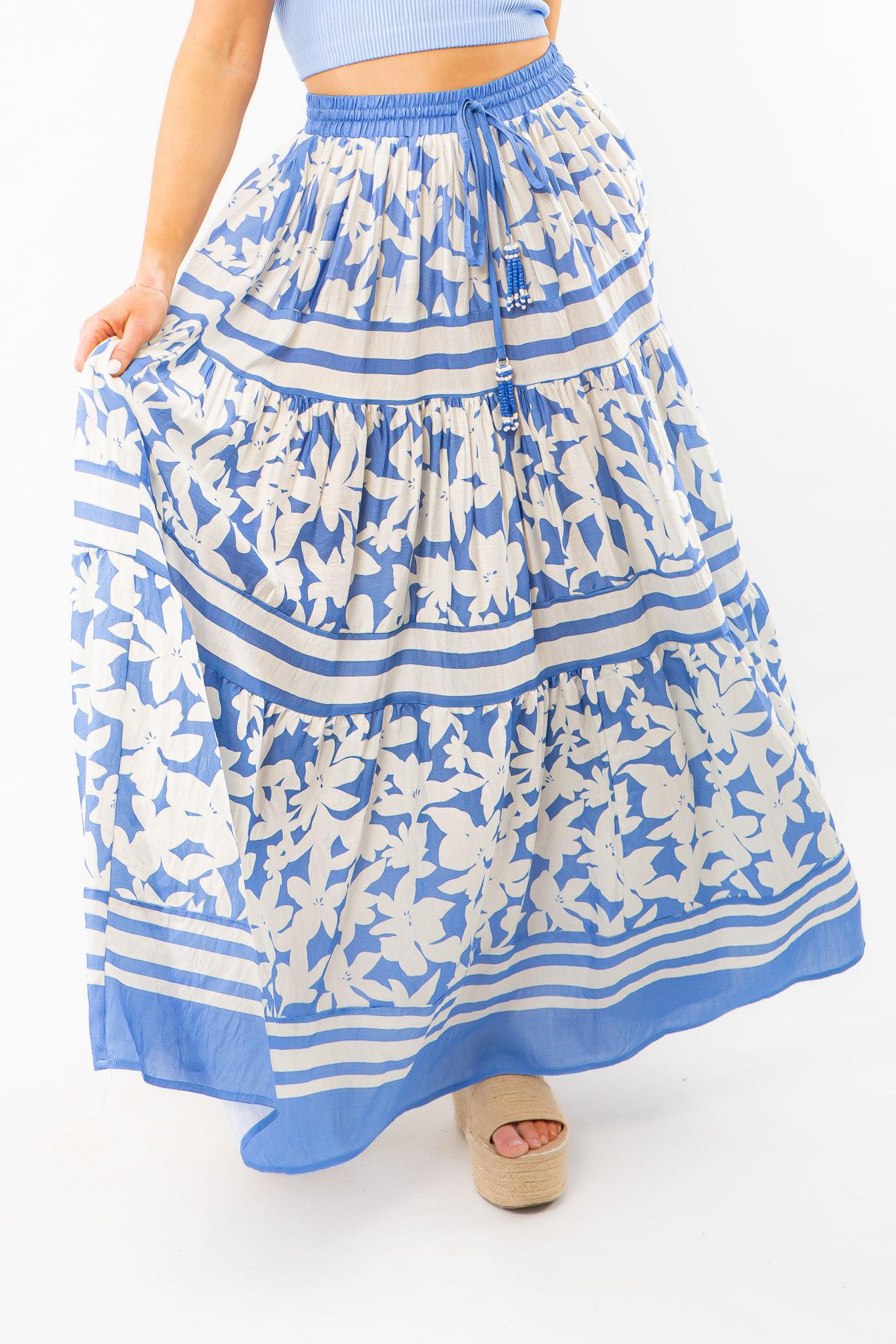 Close-up of bright blue floral print tiered maxi skirt, showcasing its flowy fabric, intricate pattern, and tassel drawstring waist.