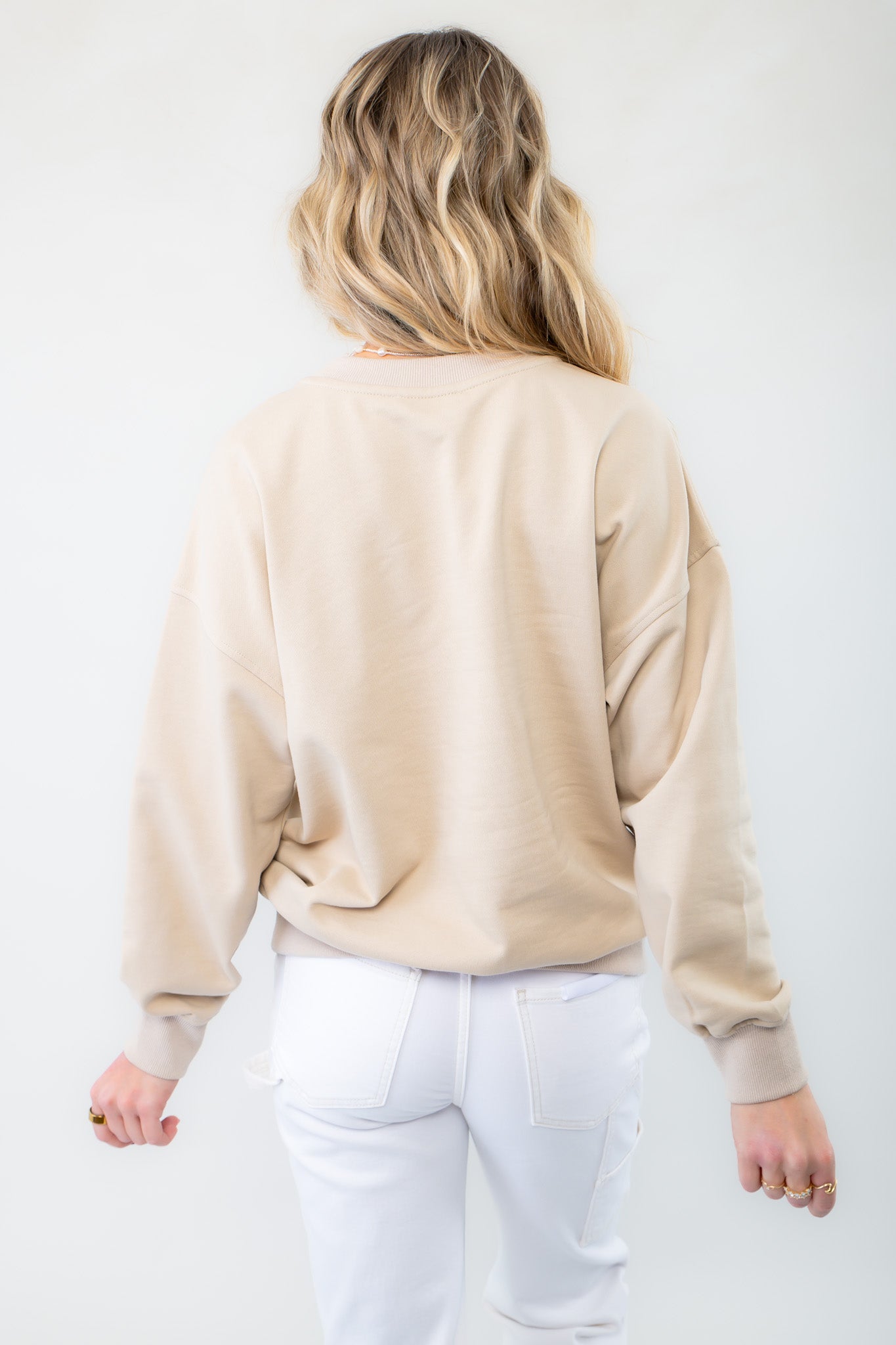 Back view of the Cowgirl Surf Club Graphic Sweatshirt in taupe. Features a classic crew neckline and ribbed cuffs for a comfortable and stylish fit.