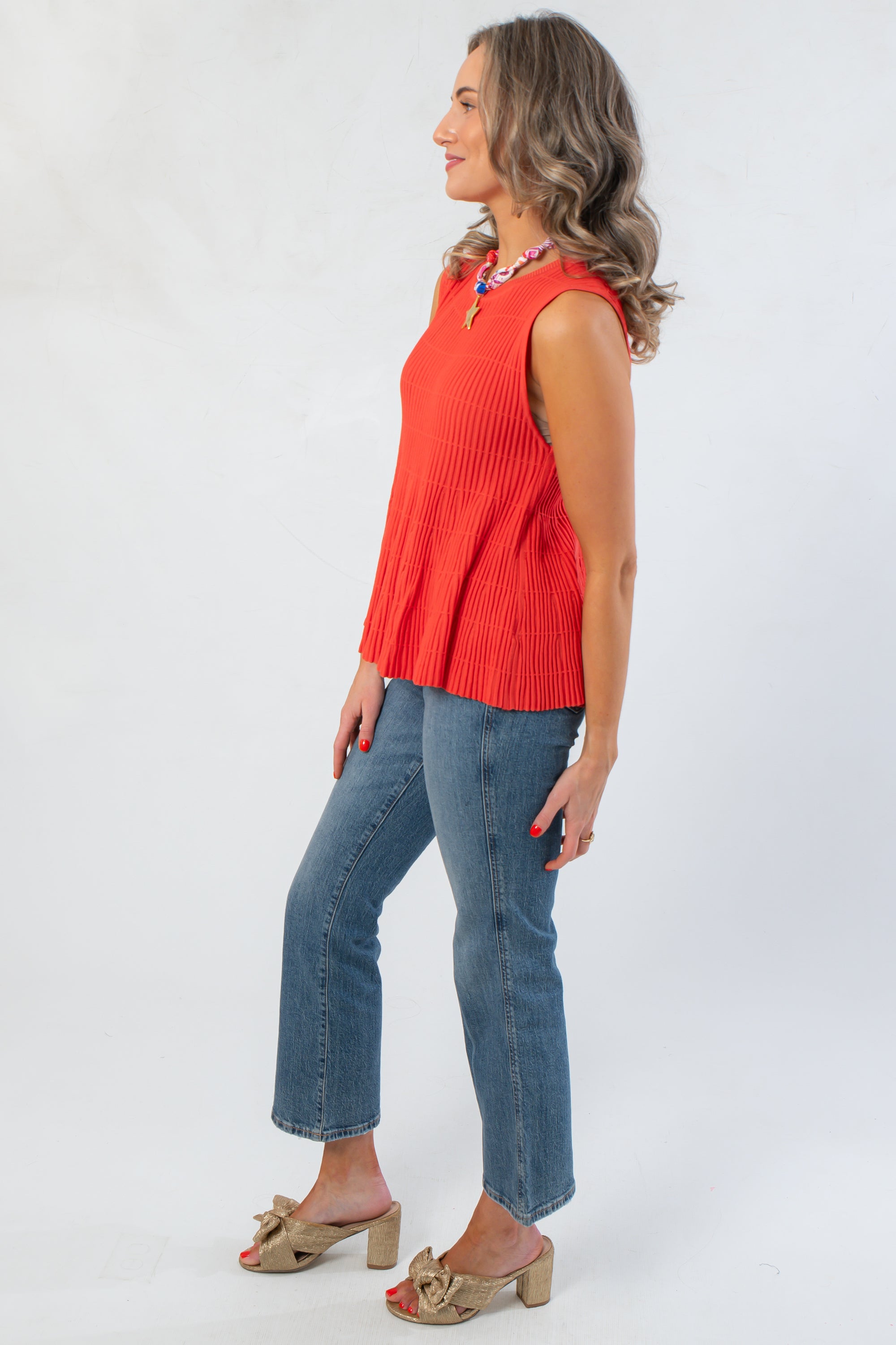 Side view of Papaya Flared Rib Knit Top highlighting the sleeveless cut and flared peplum design, perfect for layering or standalone wear.