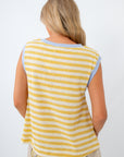 Woman wearing a yellow and white striped sleeveless top on a white background