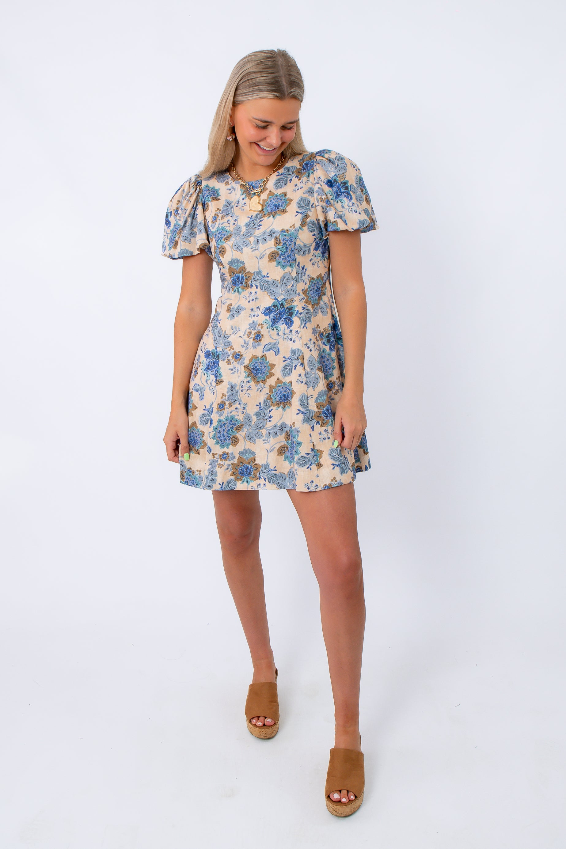 Side view of floral puff sleeve mini dress with blue and beige pattern, worn with tan wedge sandals