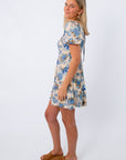 Back view of floral mini dress with puff sleeves and tie detail, styled for spring events