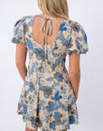 Back view of floral mini dress with open back and tie detail, beige and blue print, women's summer dress