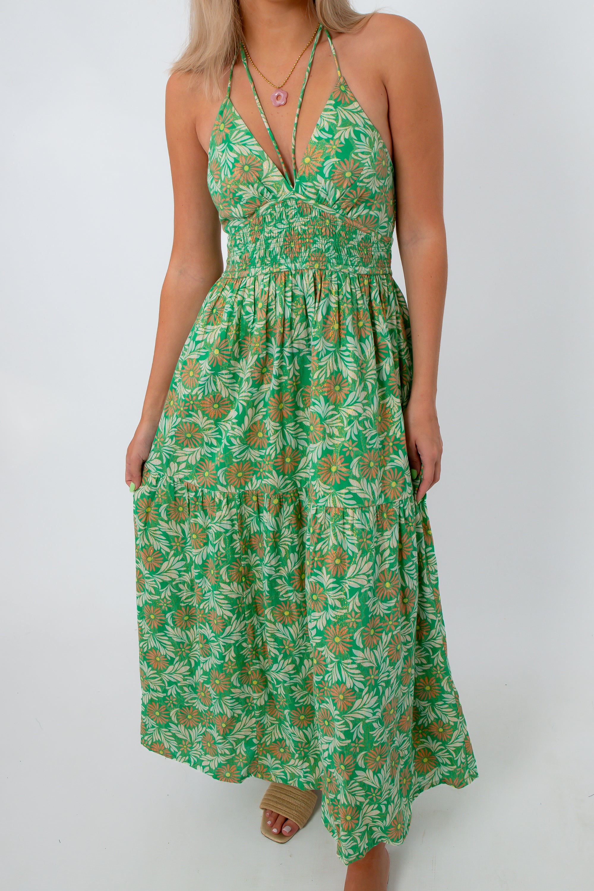 Close-up of green and orange floral maxi dress with smocked waist and tiered skirt