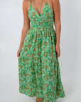 Close-up of green and orange floral maxi dress with smocked waist and tiered skirt