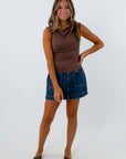 Dark wash denim mini skirt with zipper pockets paired with brown cowl neck sleeveless top, 