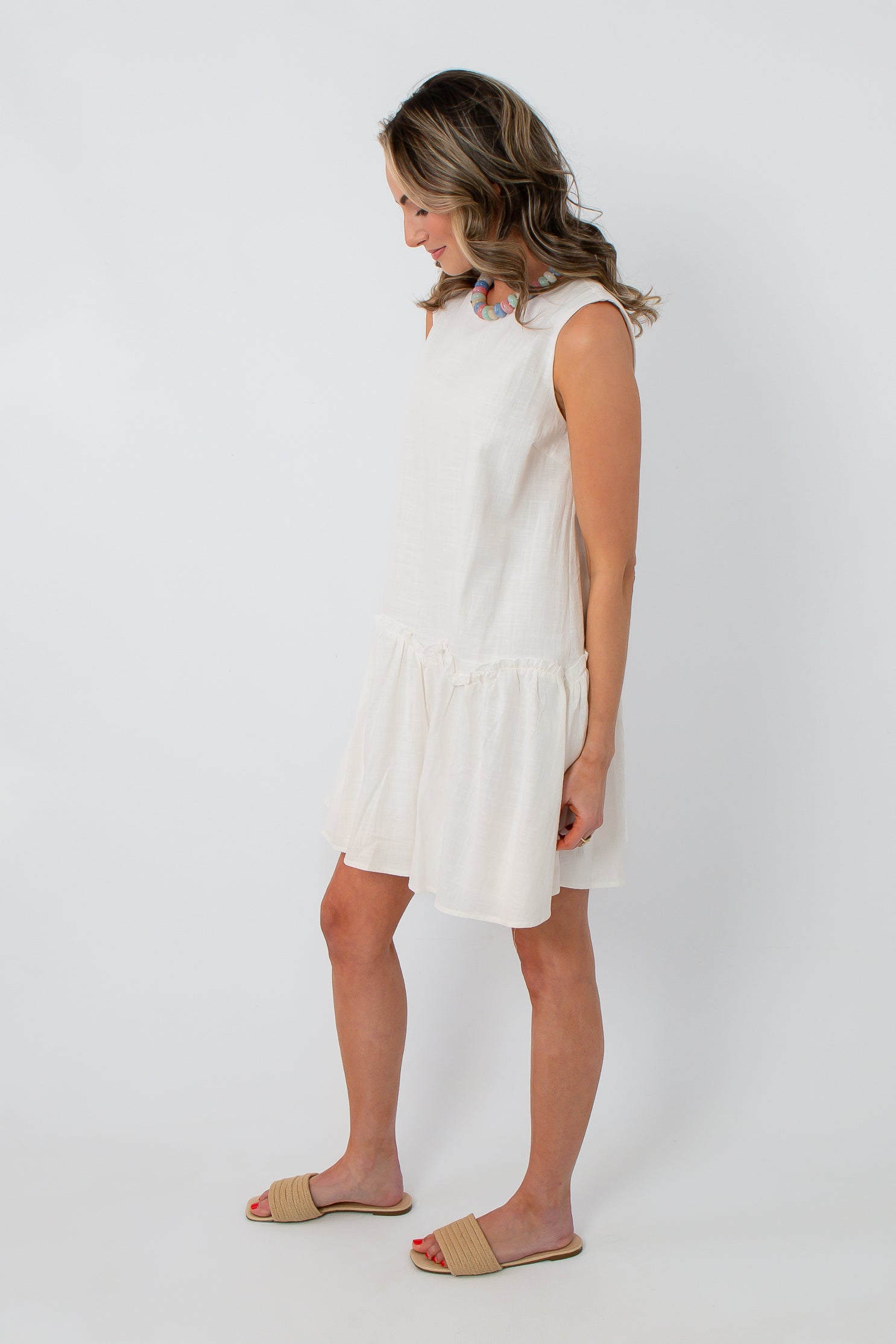 Back view of white cotton scallop hem mini dress with keyhole closure