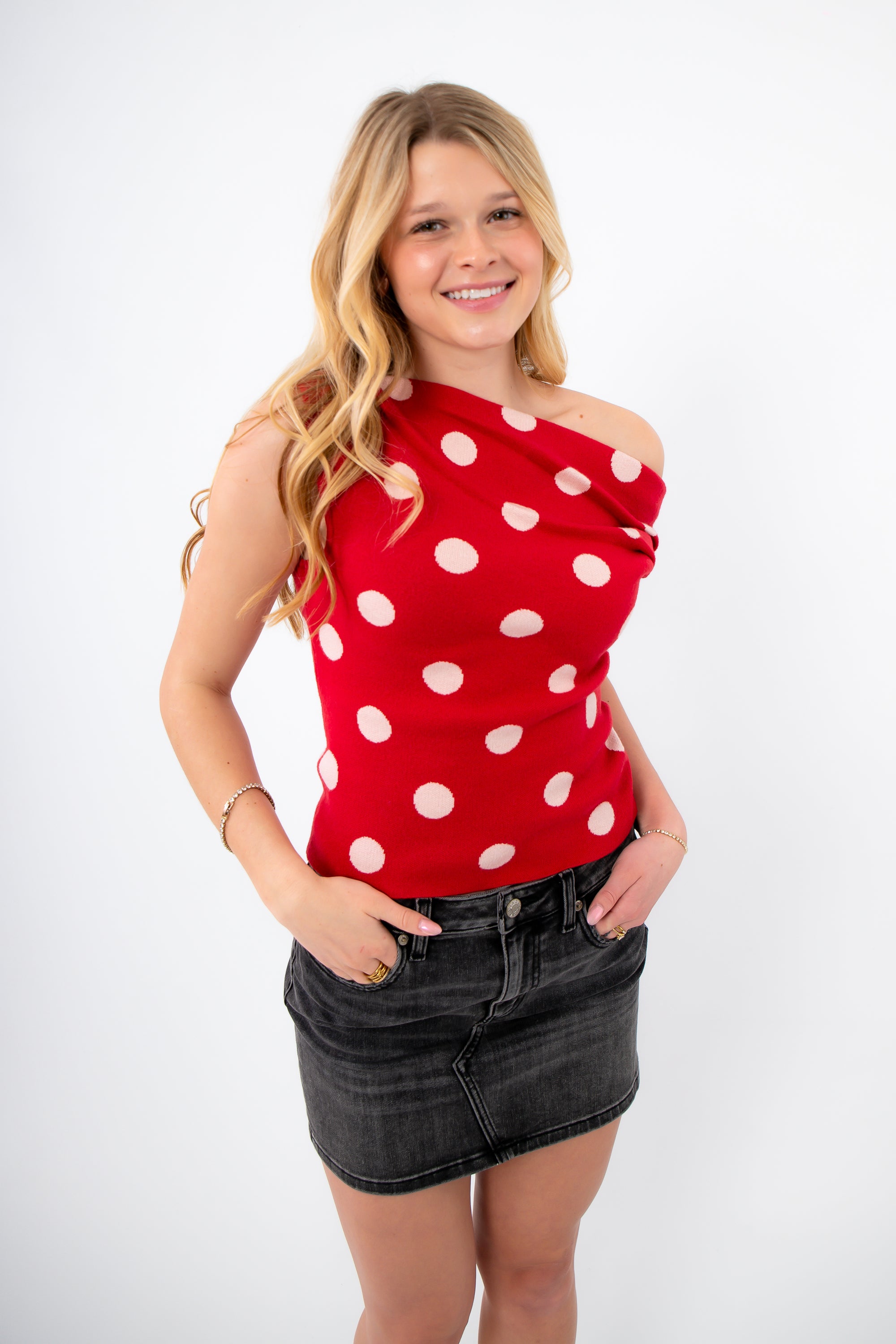 Retro Romance Red Polka Dot Asymmetrical Top worn off-shoulder, paired with a black skirt for a flirty Galentine-to-Valentine look.
