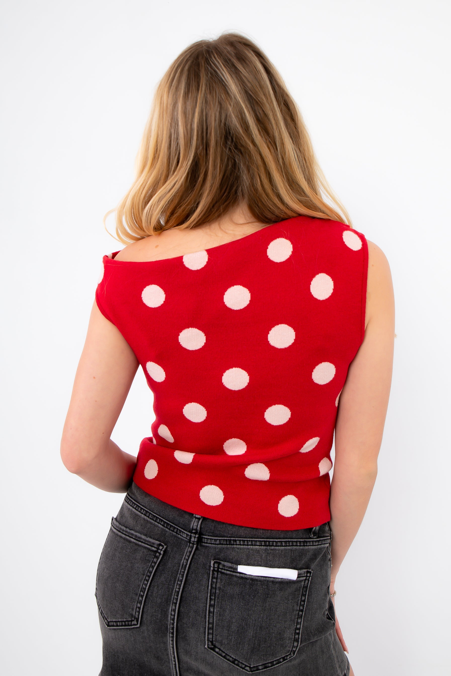 Back view of Retro Romance Red Polka Dot Asymmetrical Top showing unique neckline and seamless fit, great for casual to dressy wear.