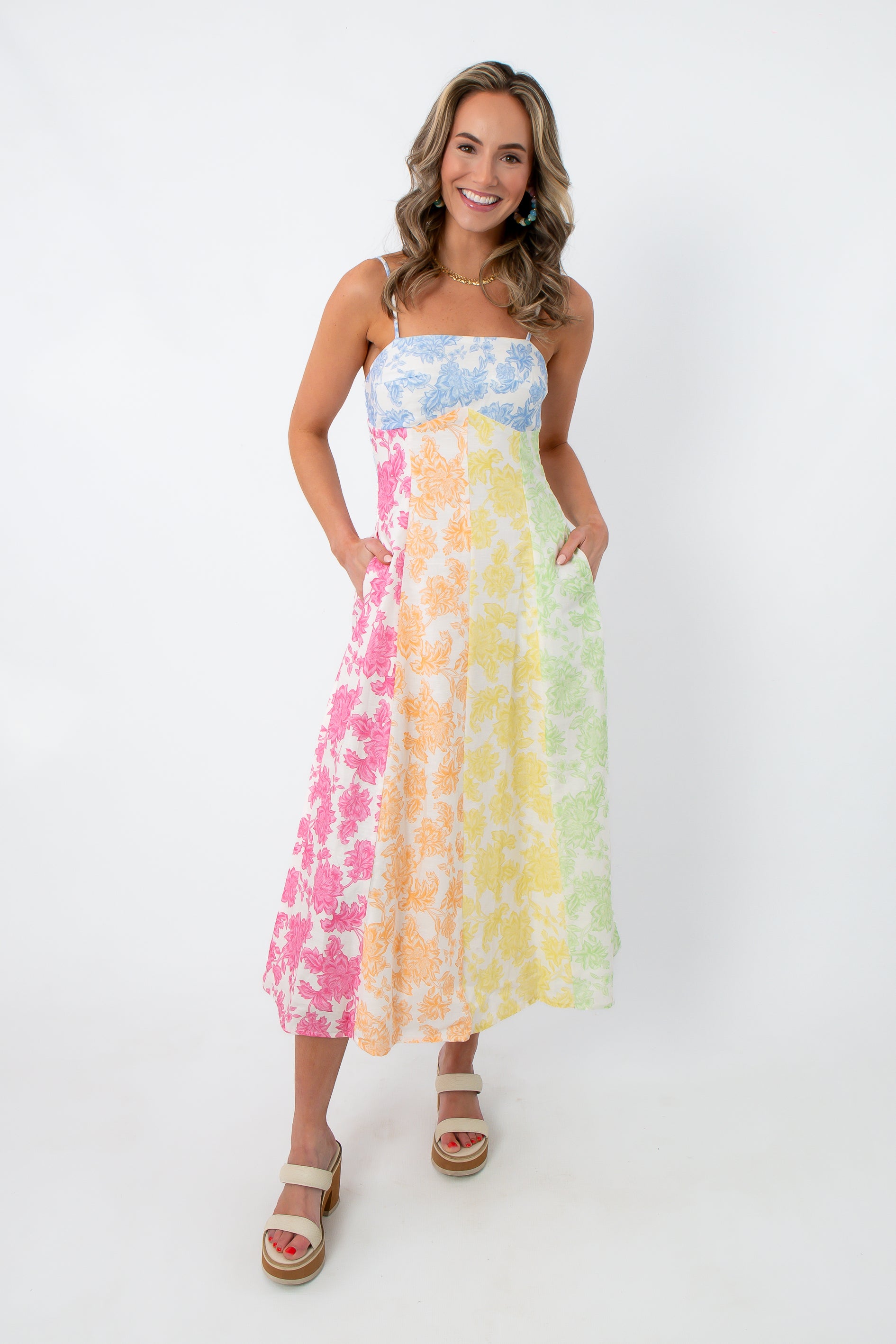 Model wearing rainbow floral sleeveless midi dress with adjustable straps