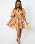 Pink and orange floral mini dress with puff sleeves, styled with beige bow heels and pearl handbag