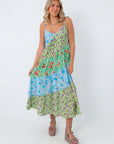Back view of vibrant tiered midi dress with floral and leaf patterns, adjustable straps, lightweight gauze fabric for summer