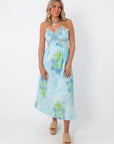 Allium Field Floral Embroidered Midi Dress with blue floral embroidery, spaghetti straps, and a low back, styled with beige platform sandals