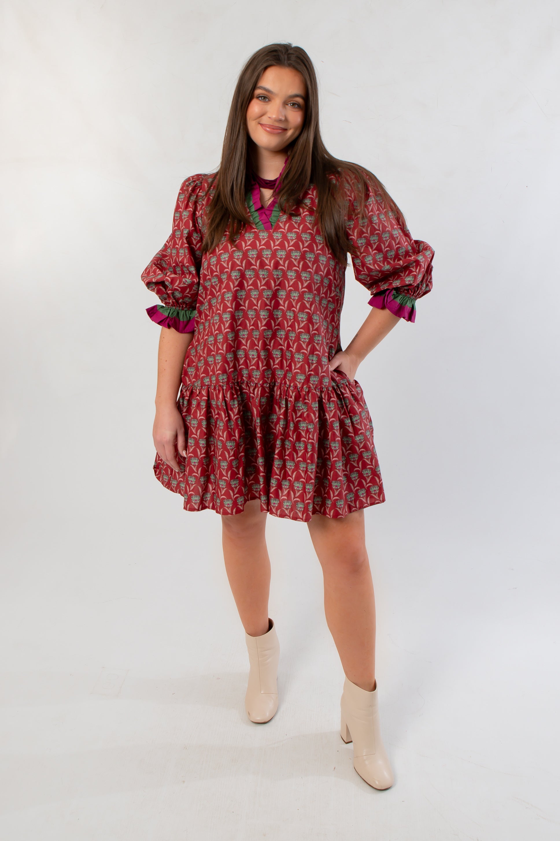 Mulberry Mistletoe Block Print Dress with festive red and green pattern, long puff sleeves, and ruffled hem, styled for holiday wear.