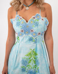 Close-up of model wearing Allium Field Floral Embroidered Midi Dress with floral embroidery and blue necklace, showcasing spring fairy vibes