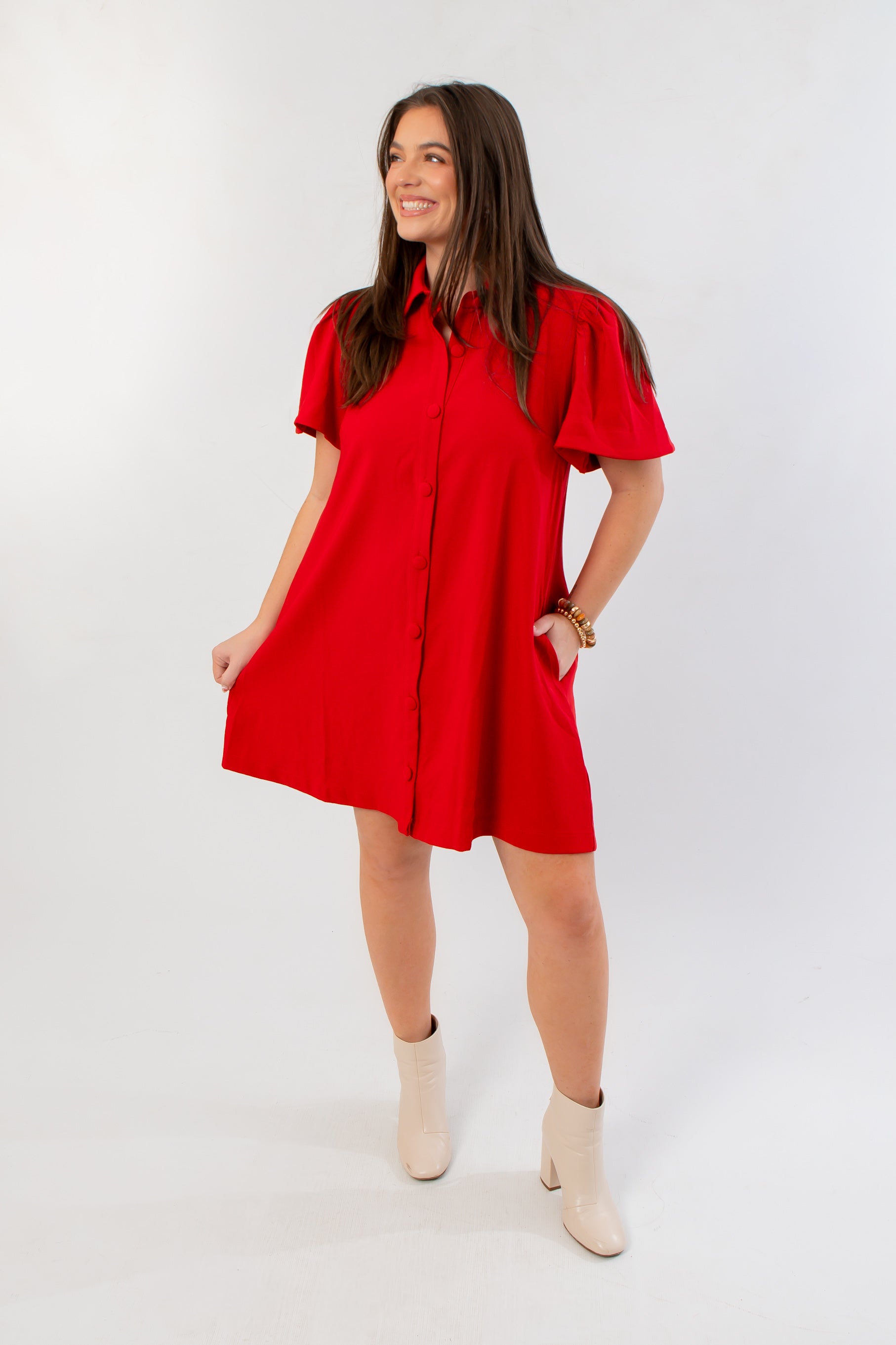 Holiday-ready Eloise Red Crepe Button Mini Dress styled with ankle boots, featuring a flattering A-line silhouette and bold red color.