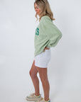 Oversized green corded sweatshirt with text, casual beachwear style