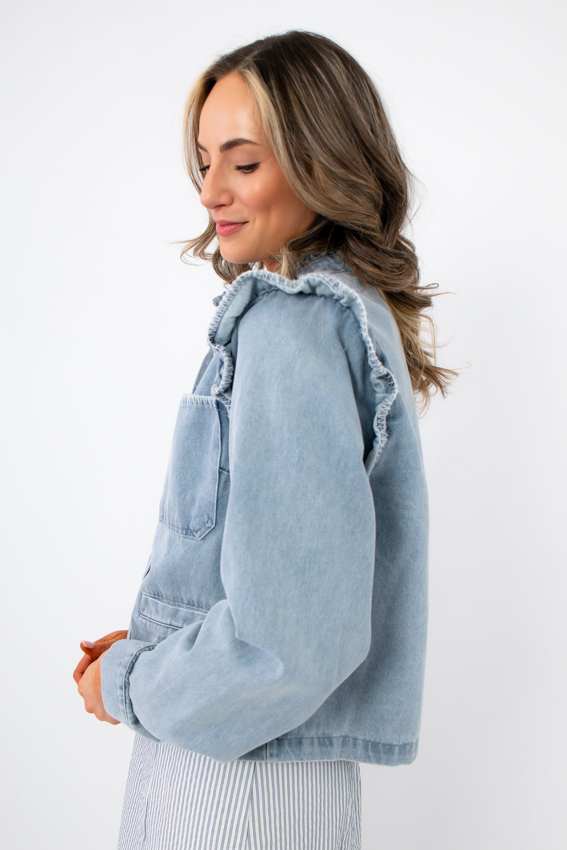 Side view of Ruffle-Trim Light Wash Denim Jacket showing soft ruffle detailing and relaxed fit, perfect for layering in spring fashion.