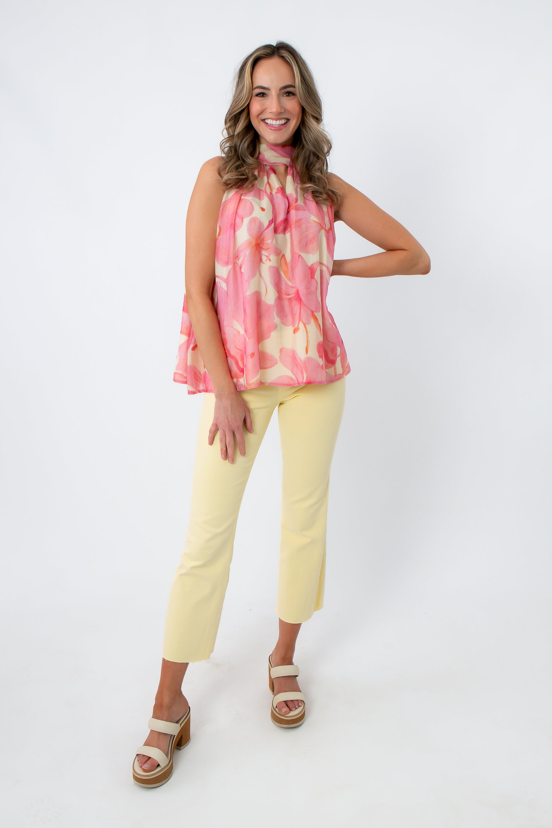 Model wearing pink floral sleeveless blouse with yellow pants