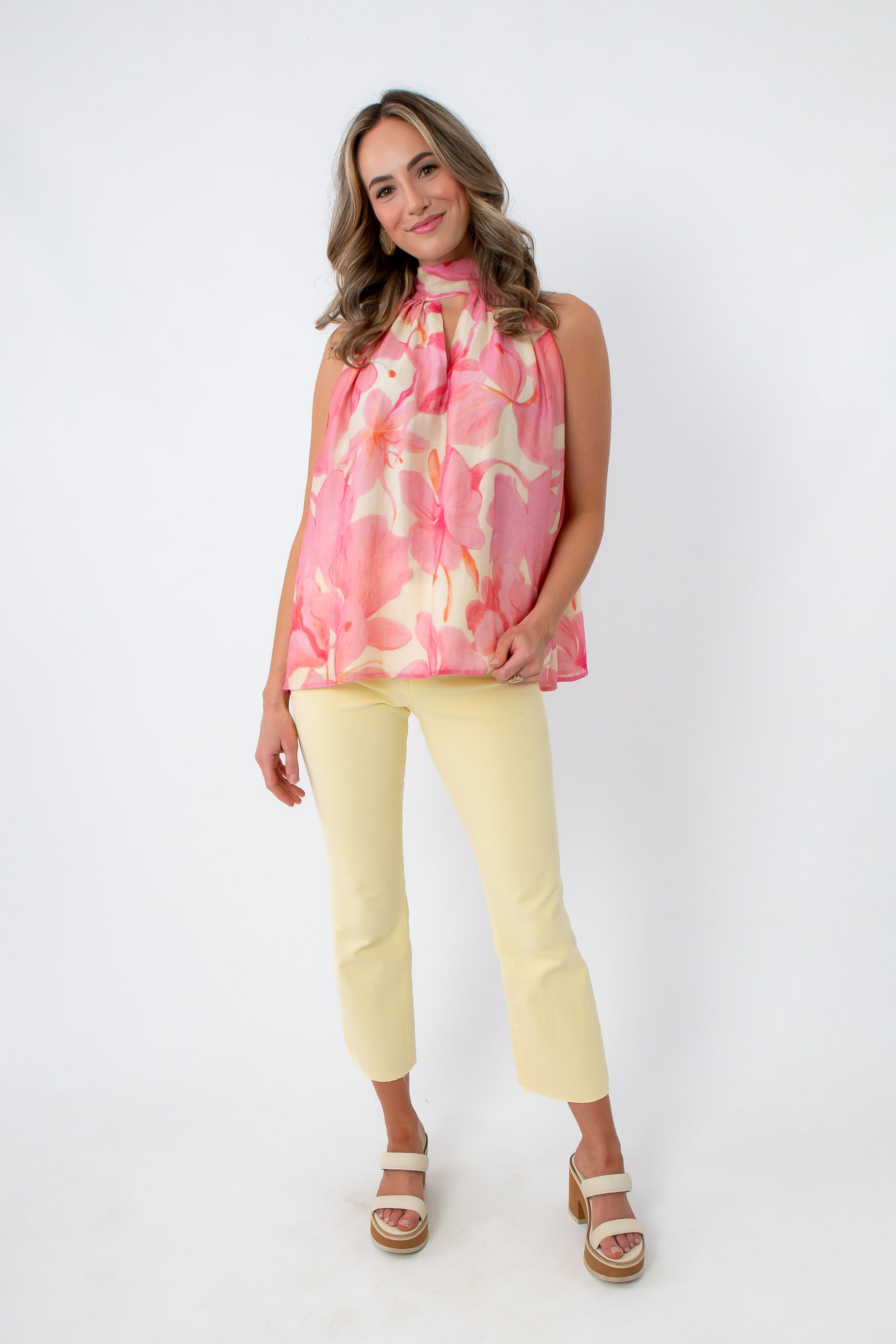 Pastel yellow ankle flare jeans with a flattering fit, styled with a pink floral top and platform sandals