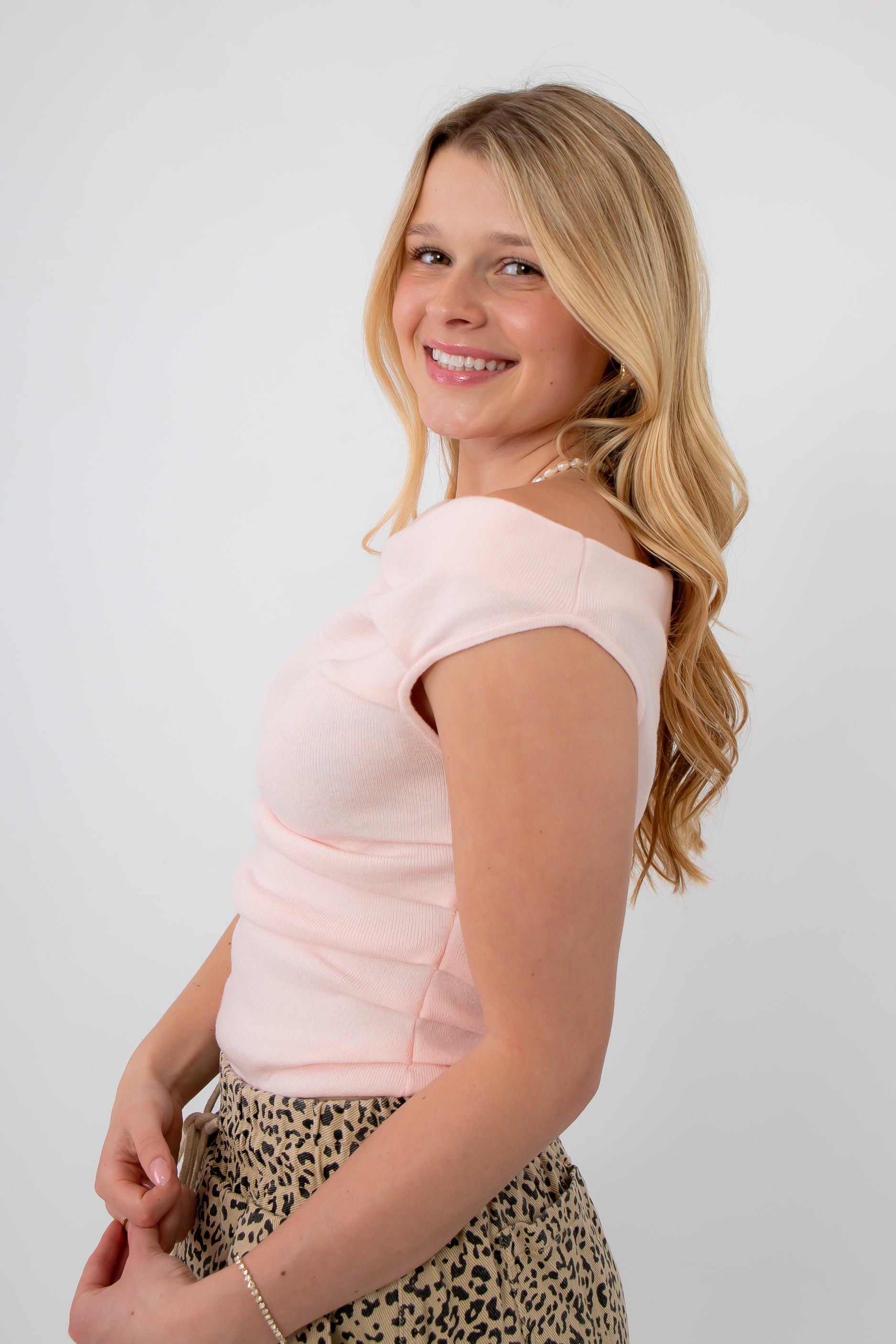 Side view of Friday Feeling Baby Pink Asymmetrical Knit Top showing soft blush hue and flattering fit, ideal for spring outfits.