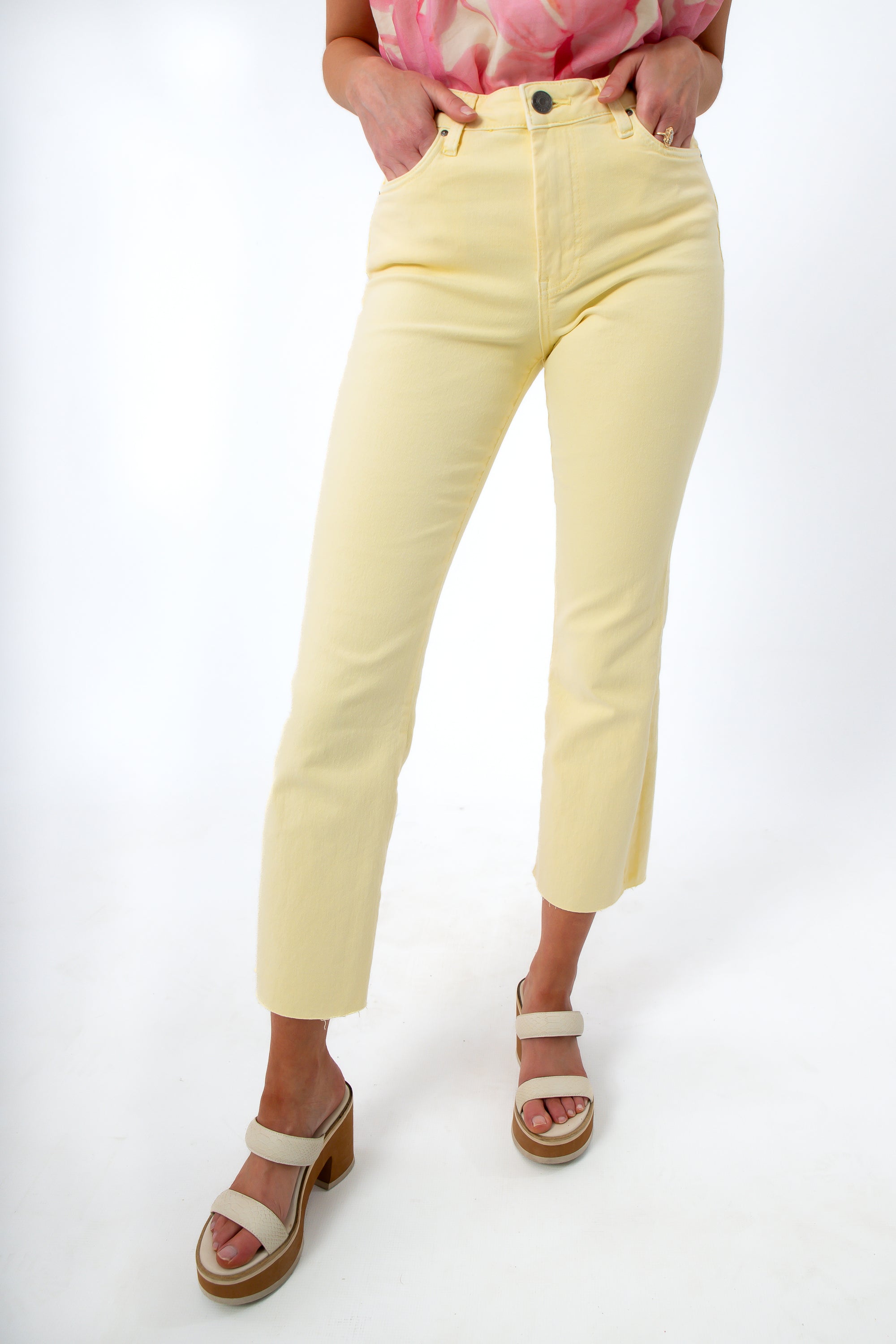 Close-up of pastel yellow denim jeans showing front pockets and waistband detail