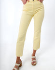 Close-up of pastel yellow denim jeans showing front pockets and waistband detail