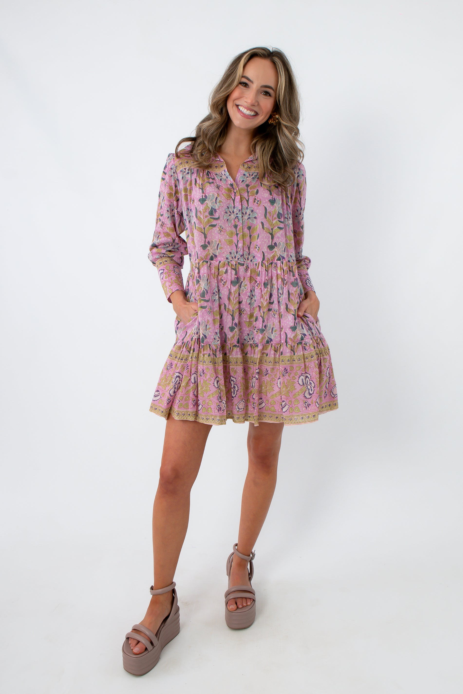 Long sleeve floral mini dress with pink and purple pattern, collared neckline, and pockets, styled with platform heels