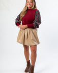 Front view of THML Mixed Media Garnet Knit Top featuring textured sleeves and mock neck. Ideal for fall outfits and gameday looks.