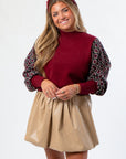 Close-up of THML Mixed Media Garnet Top showcasing detailed knit sleeves and rich garnet color. Stylish long sleeve top for seasonal wardrobes.
