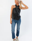 Black Faux Leather Halter Top featuring a sleek crossover front and sleeveless design, paired with denim for a versatile outfit.