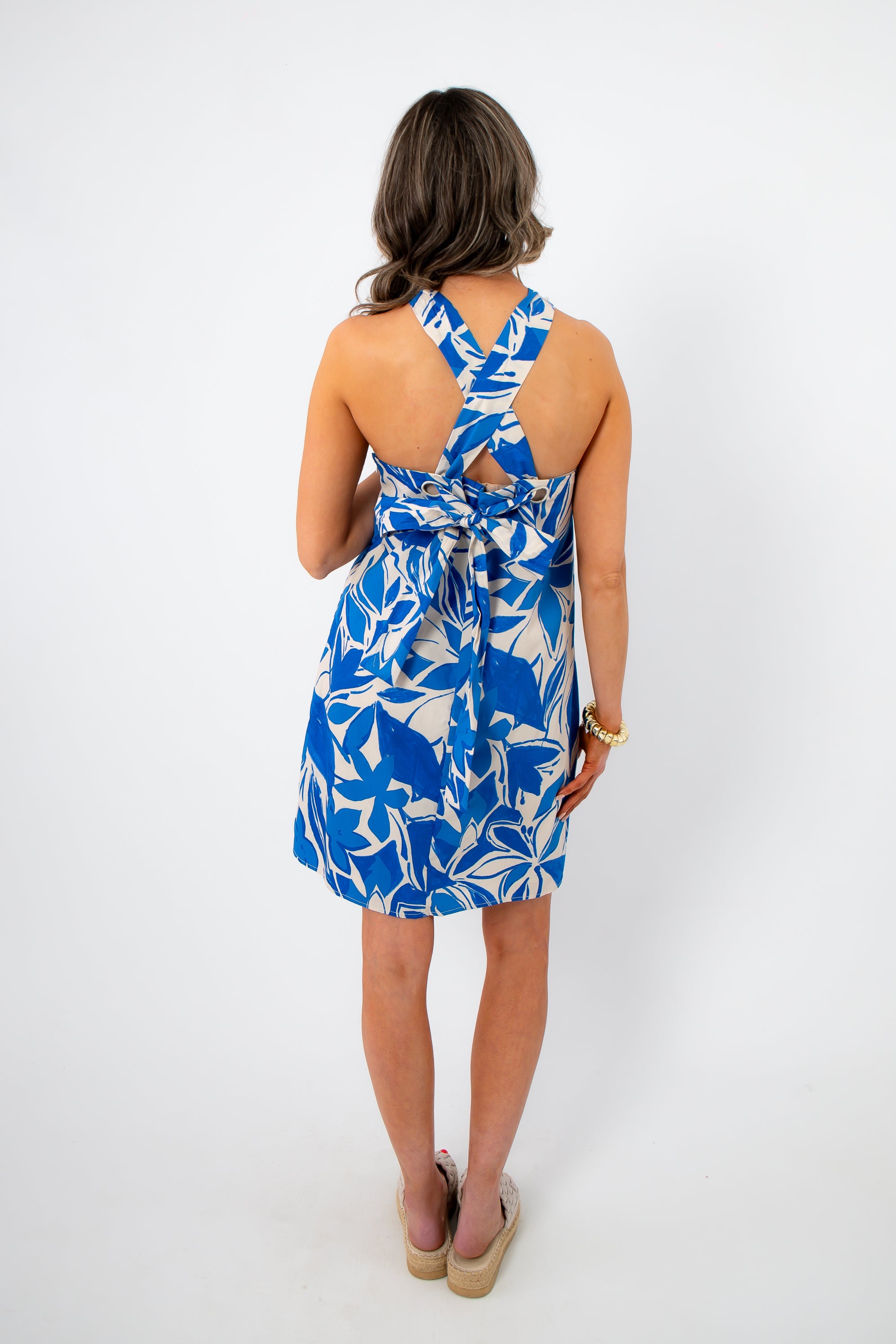 Back view of the Santorini Skies Halter Dress with crisscross straps and a tied bow detail, perfect for vacation styling.