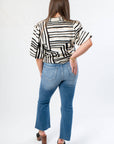 Back view of Medium Wash High Rise Crop Flare Jeans with classic pocket design and raw hem. A trendy staple for versatile styling.