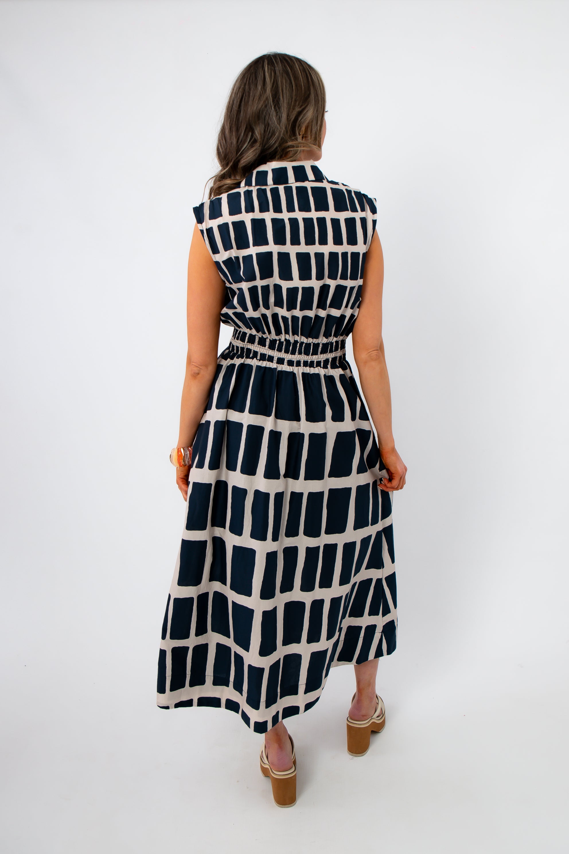 Back view of Newport Knot-Front Navy Midi Dress featuring elastic waistband and bold geometric pattern, ideal for versatile summer styling.