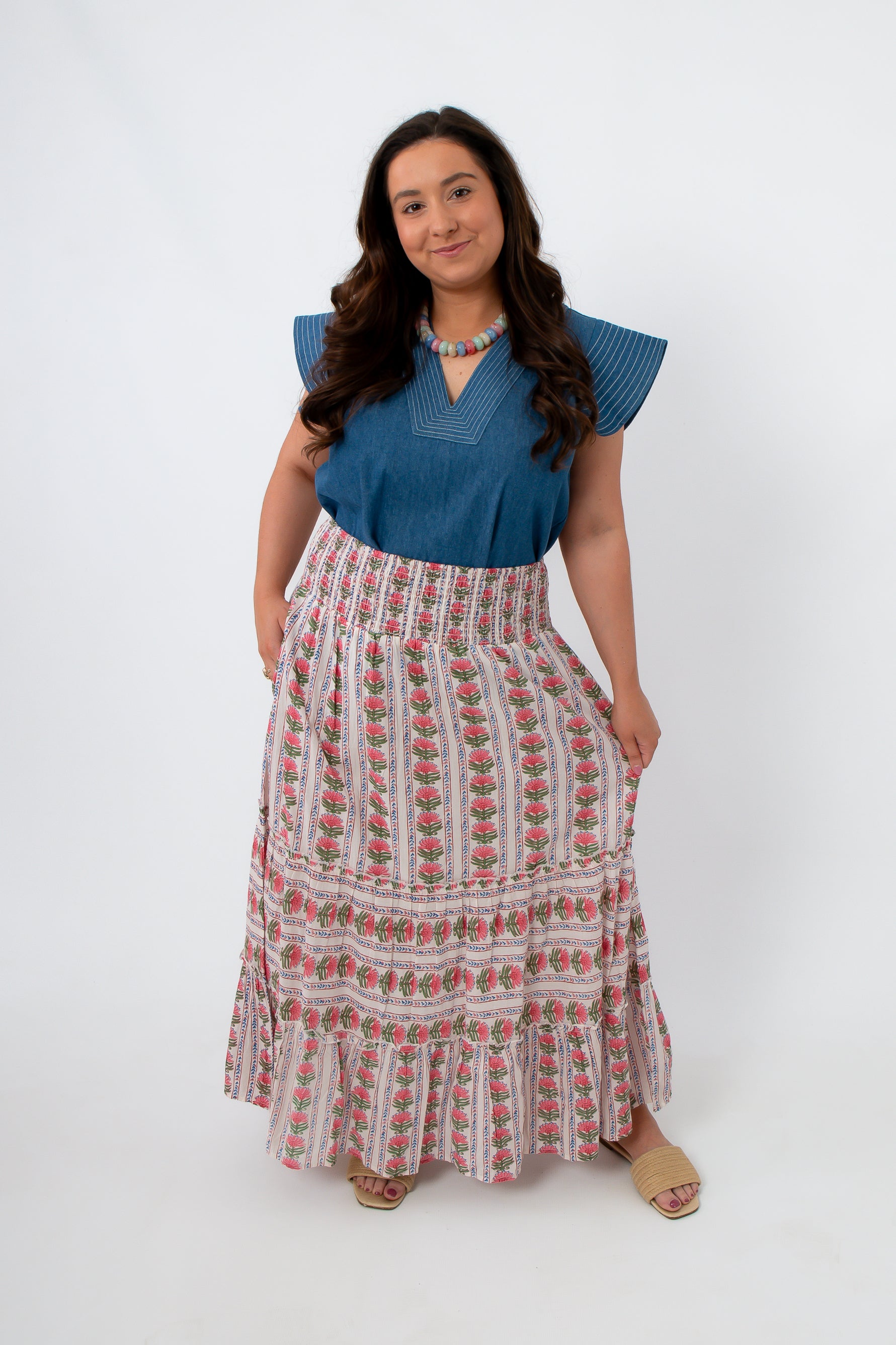 Model wearing floral midi skirt with smocked waist and side pockets