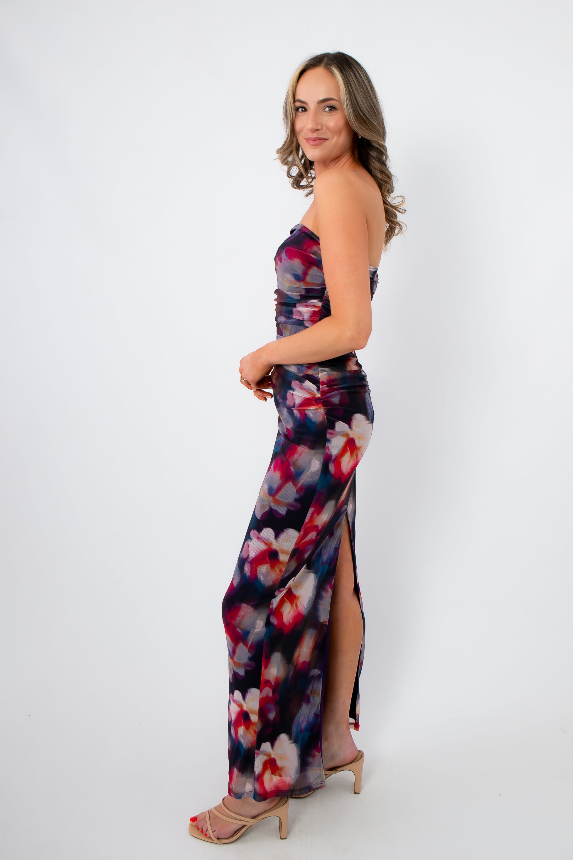Side view of Amethyst Petal Mesh Maxi Dress featuring a vibrant purple floral print, body-hugging fit, and side slit for spring and summer occasions.