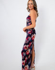 Side view of Amethyst Petal Mesh Maxi Dress featuring a vibrant purple floral print, body-hugging fit, and side slit for spring and summer occasions.