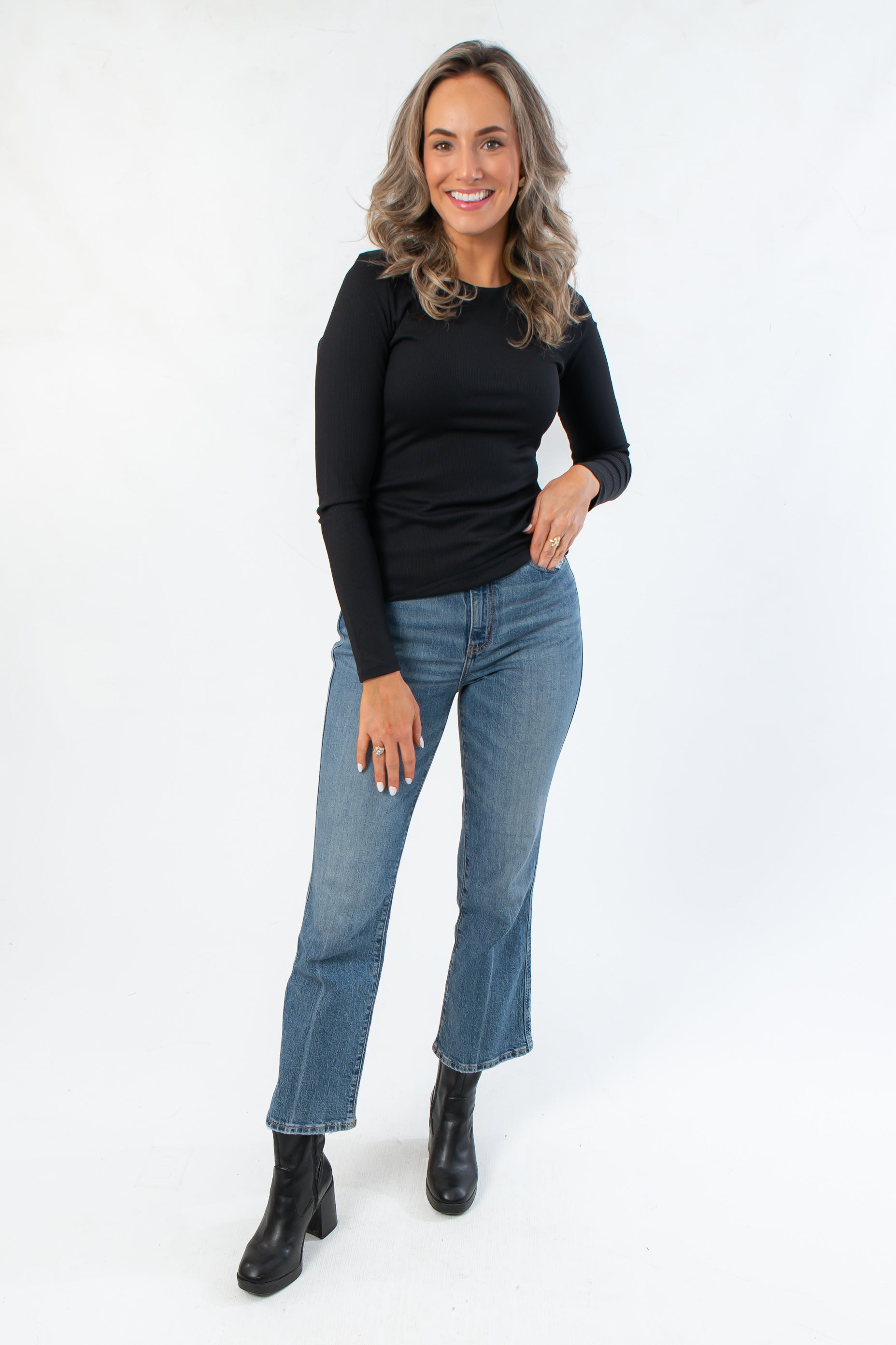 Roxi Jet Black Ribbed Knit Top styled with blue jeans and black boots, a fitted long sleeve essential for layering in fall fashion.