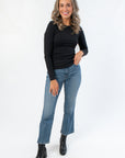 Roxi Jet Black Ribbed Knit Top styled with blue jeans and black boots, a fitted long sleeve essential for layering in fall fashion.